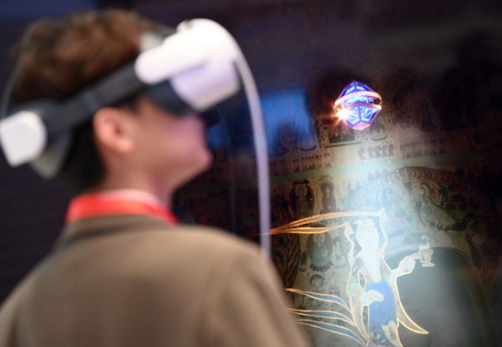 9月17日，与会嘉宾在论坛的文化遗产数字化精品项目展上体验敦煌研究院《寻境敦煌》项目。