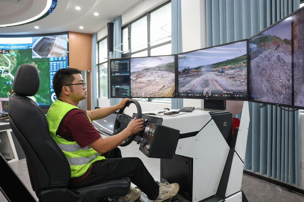 9月17日，在海南定安县大岭花岗岩矿项目现场，工作人员监测无人驾驶矿卡的运行情况。