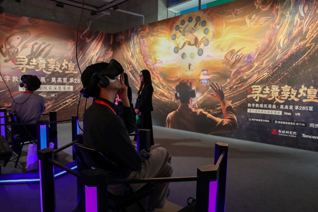 9月21日，在第八届丝绸之路（敦煌）国际文化博览会上，与会嘉宾借助VR设备沉浸式游览莫高窟虚拟场景。