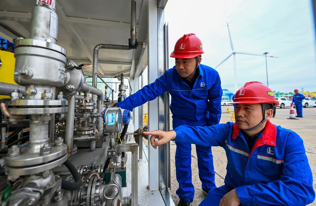 9月22日，在天津港环球滚装码头，工作人员在加注前检查设备。