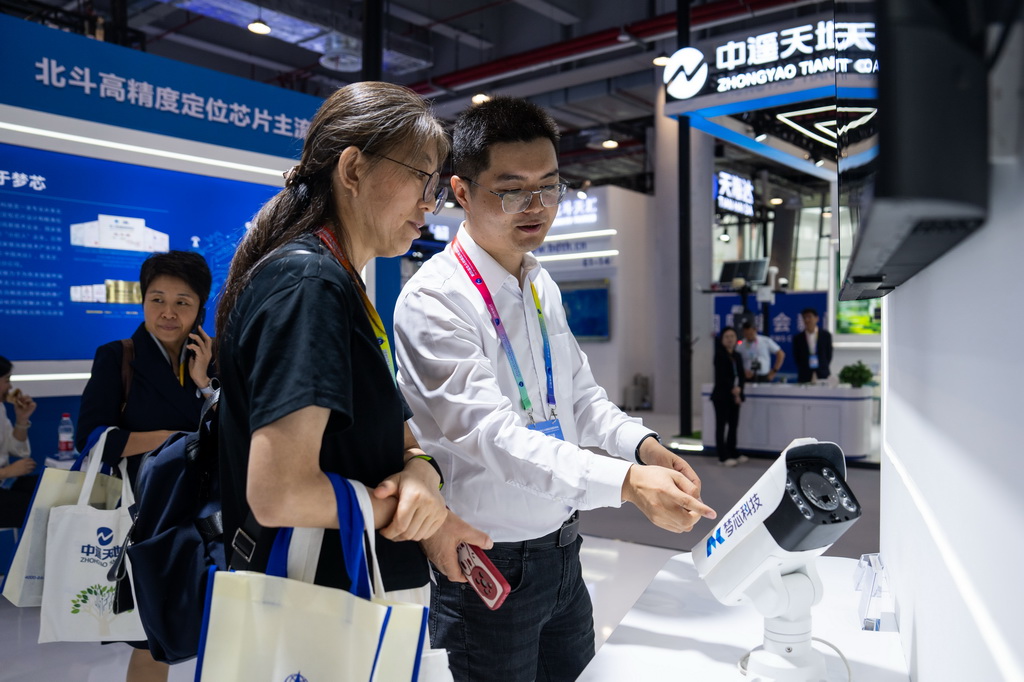 9月24日，在株洲国际会展中心，工作人员（右）在介绍一台配有北斗技术的监控设备。