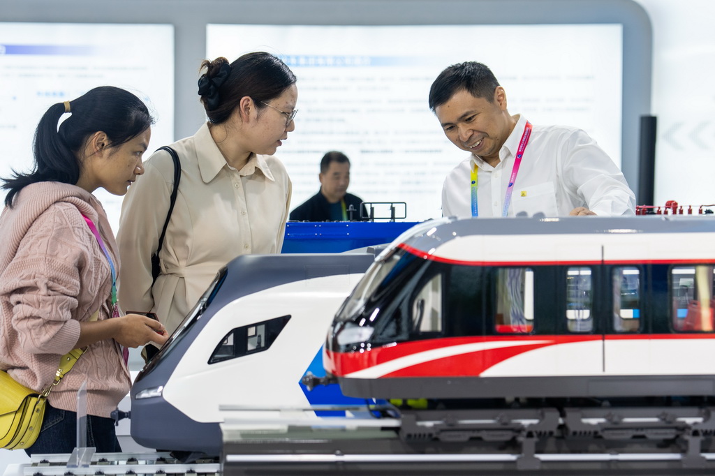 9月24日，在株洲国际会展中心，工作人员（右一）在介绍国产动车组列车。