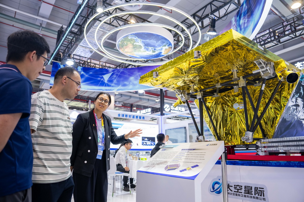 9月24日，在株洲国际会展中心，工作人员（左三）在介绍一台对地观测卫星。
