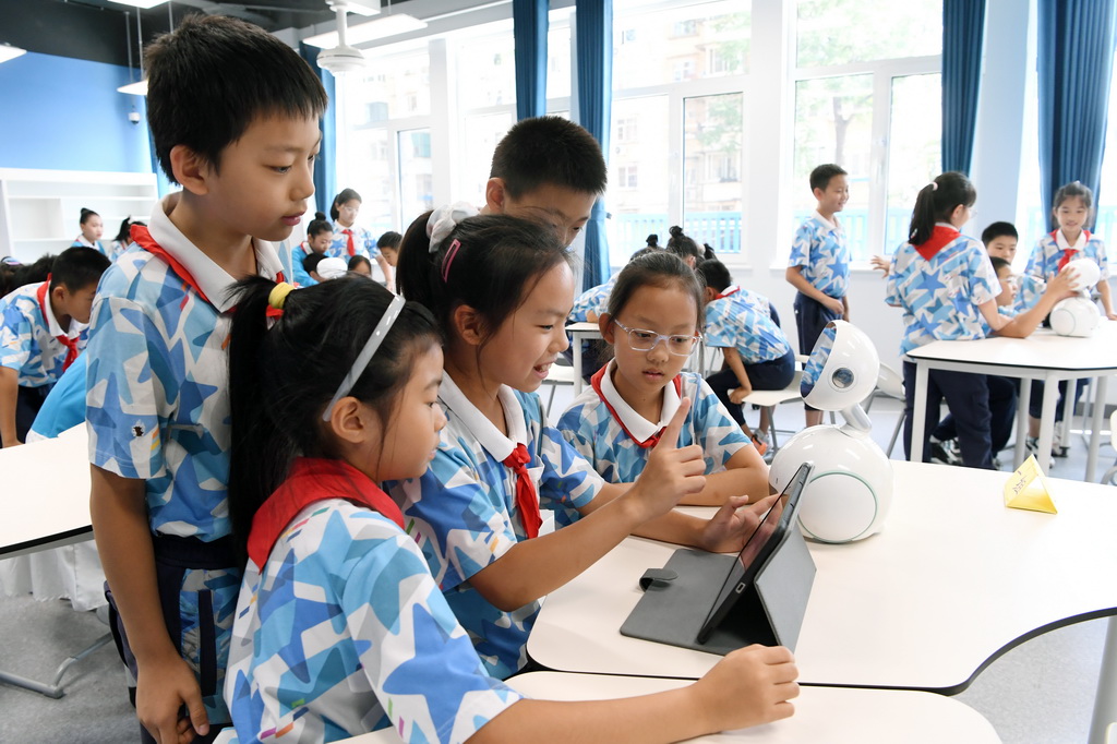 9月24日，北京市第二十中学附属育鹰小学学生在人工智能教育通识课《从国防到生活——AI人脸识别》了解人脸识别技术。