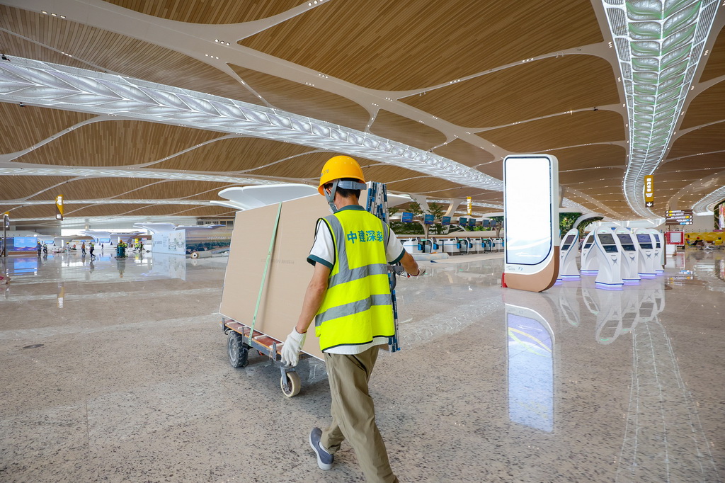 9月29日，施工人员在广州白云机场T3航站楼出发大厅运输石膏板。