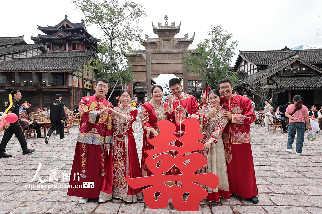 10月1日，在四川省宜宾市叙州区的宜宾长江公园，“宜见倾心·爱在宜宾——蜜月之旅长长久久·江江好”活动火热举行。26对新人举行集体婚礼，乘坐双层爱情巴士，开启一场串联城市地标、融合文旅风情的浪漫巡游。兰锋摄（人民图片网）