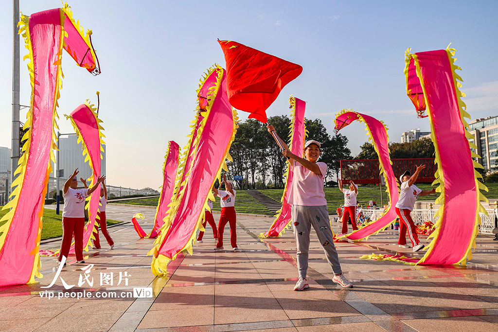 10月1日，山东青岛西海岸新区市民广场，西海岸龙舞队的队员们舞起彩龙，喜庆国庆佳节。韩加君摄（人民图片网）