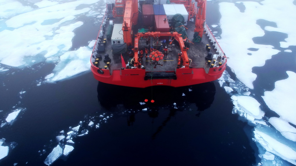 队员们布放生态海底着陆器（Lander），当时海面上有很多海冰（无人机照片，2025年7月24日摄）。新华社记者 刘诗平 摄