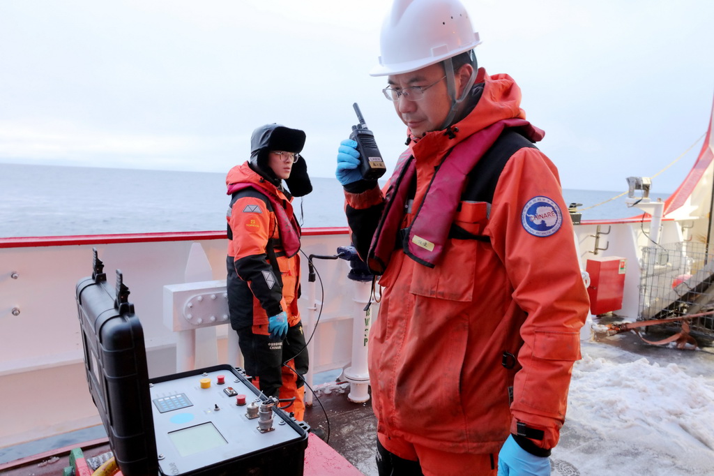 2025年9月12日，负责回收的队员任健（右）等在艉甲板测试生态海底着陆器（Lander）信号。新华社记者 刘诗平 摄