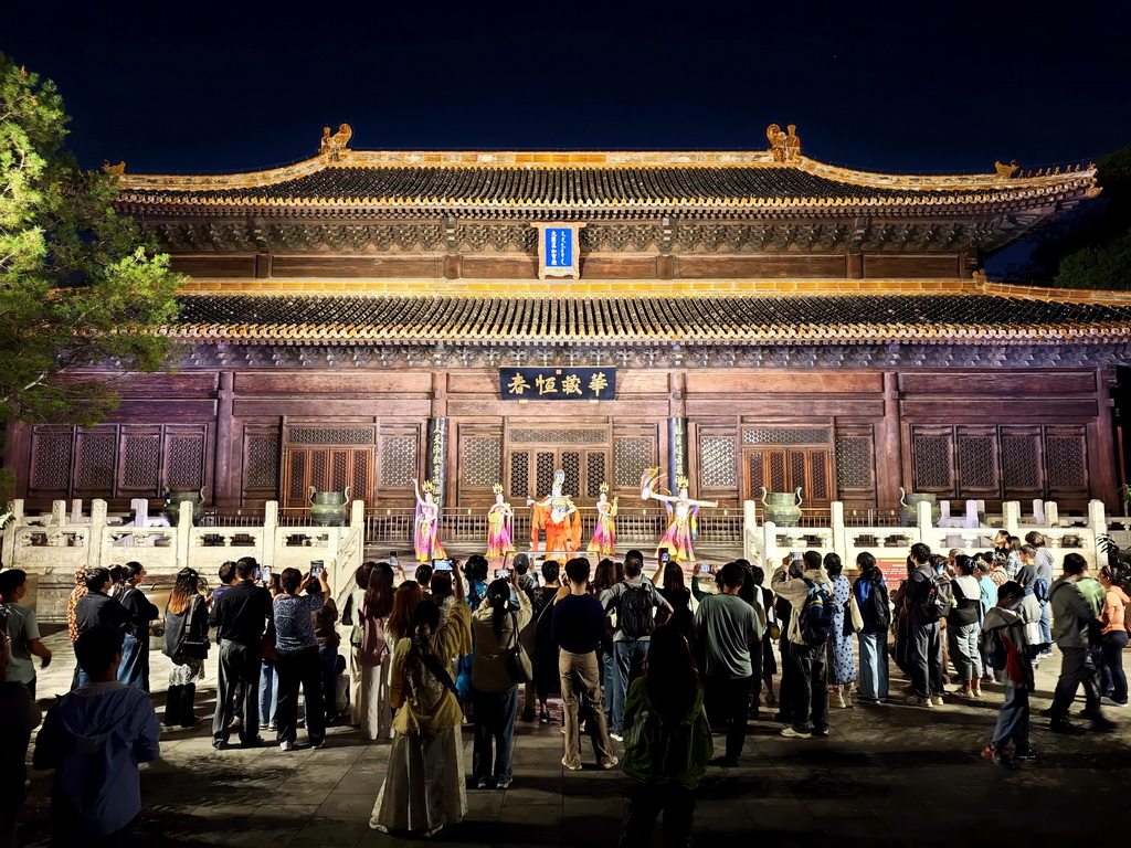 10月2日，游客在北京北海公园观看演出，在夜色中的古典园林里感受传统文化魅力。新华社记者 邢广利 摄