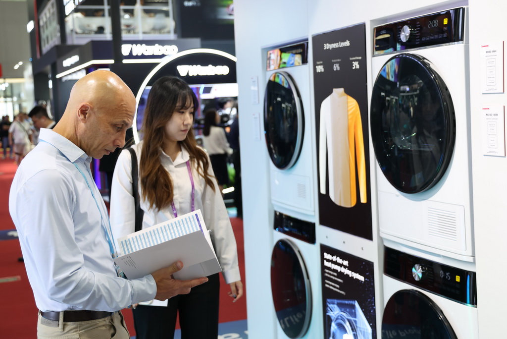 10月15日，客商在广交会上咨询了解智能洗衣机。