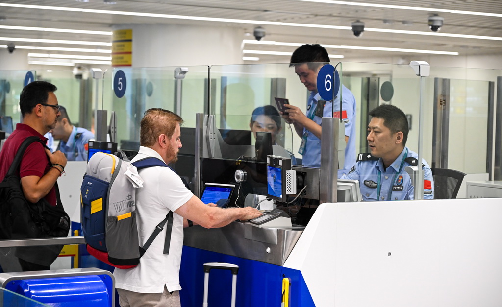 10月15日，入境旅客在海口美兰边检站办理边检手续。