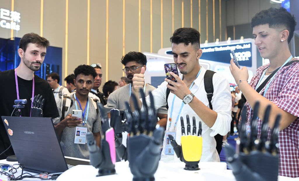 10月15日，境外采购商在第138届广交会服务机器人专区体验机器手同步动作。新华社记者 邓华 摄