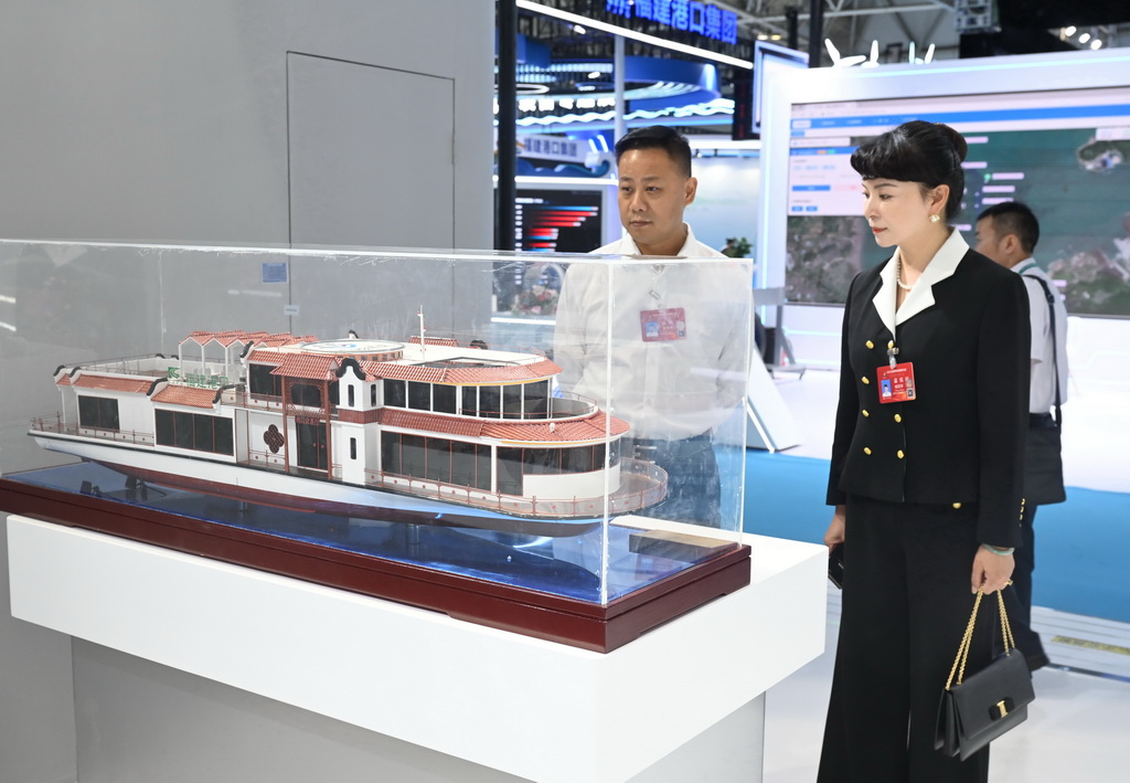 10月16日，与会人员在宁德时代展区观看“闽江会客厅”电动游船模型。新华社记者 林善传 摄