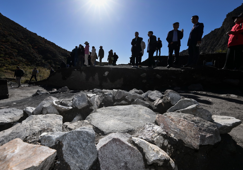 考古学家们在对苏峪口瓷窑址2025年度发掘区出土的一处石英加工遗迹进行考察（10月13日摄）。新华社记者 李贺 摄