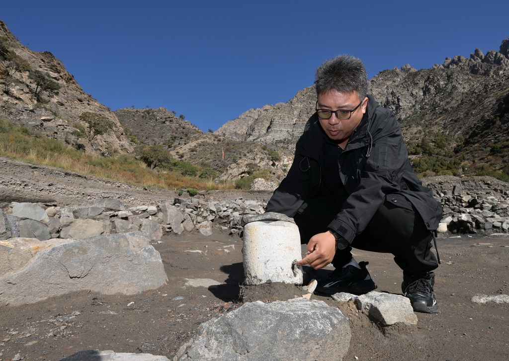 苏峪口瓷窑址考古队执行领队柴平平在2025年度发掘区一处作坊遗迹前介绍瓷器烧制工艺（10月13日摄）。新华社记者 李贺 摄