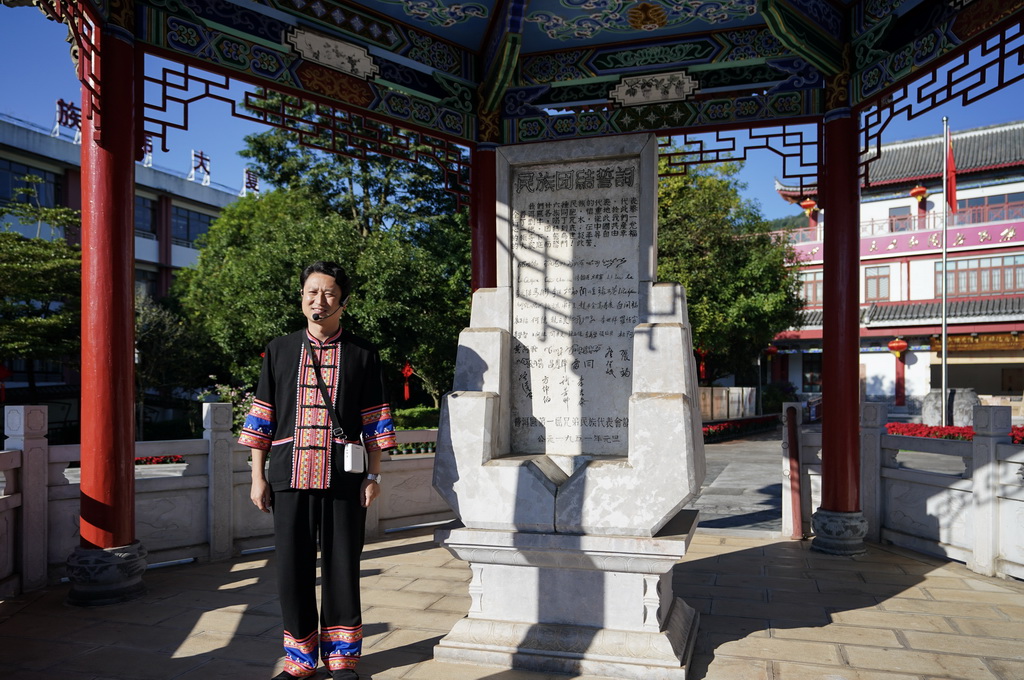 10月23日，一名讲解员在云南省普洱市宁洱哈尼族彝族自治县民族团结园内为游客介绍民族团结誓词碑。