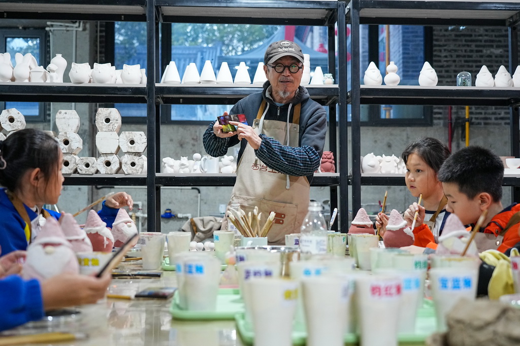 10月22日，志愿者赵锦星为淄博市博山区中心路小学学生讲解陶瓷制作技艺。