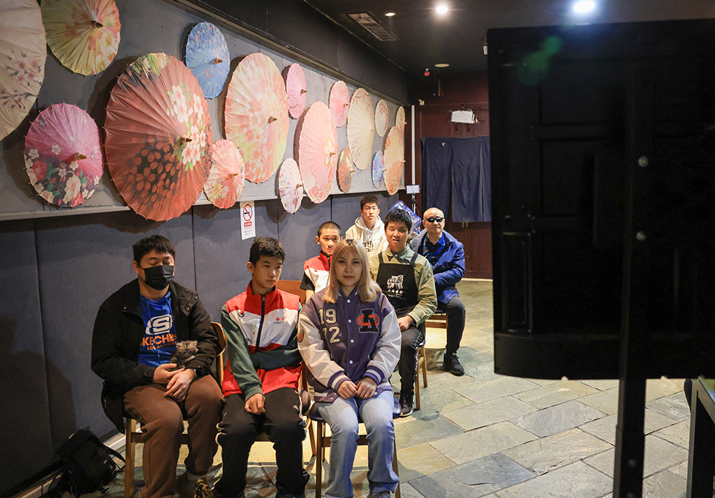 10月26日，在木马童话黑暗餐厅，视力障碍人士和志愿者一起观看无障碍电影。