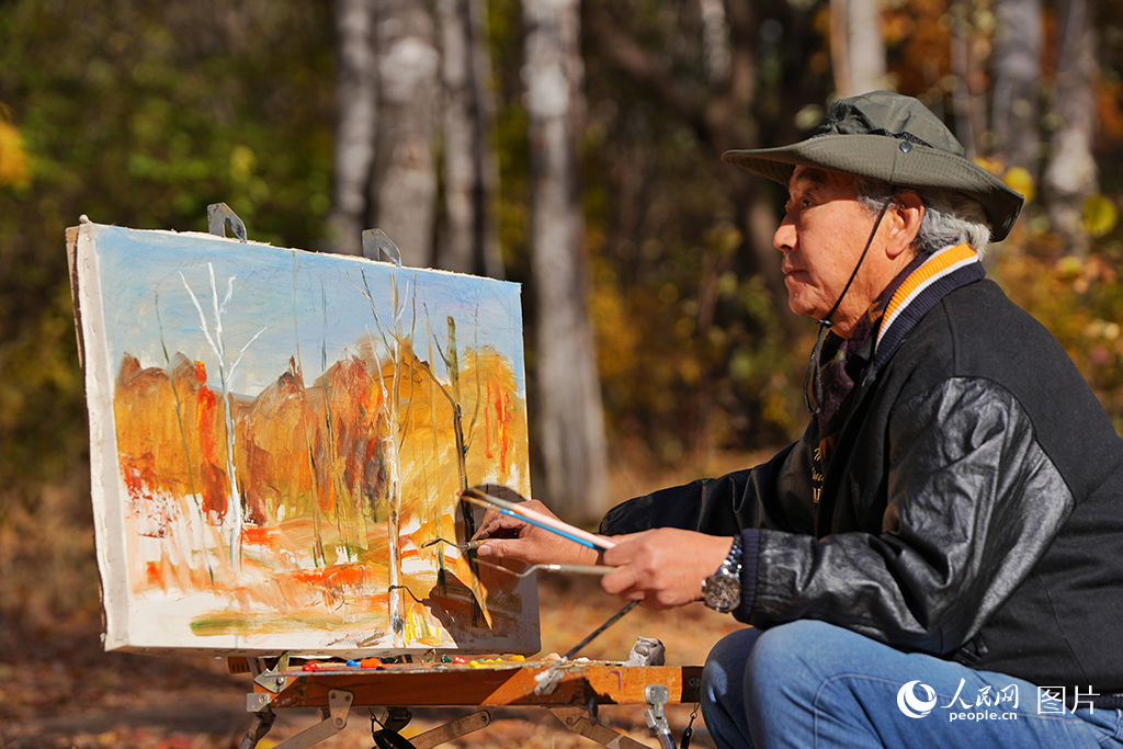 10月26日，一名长者在吉林长春南湖公园白桦林里创作油画。人民网记者 李洋摄