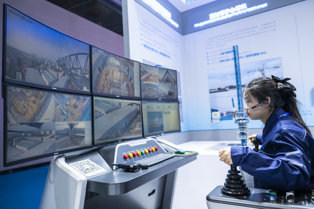 10月31日,在博览会现场,一名工作人员在展示塔机智能集控系统。