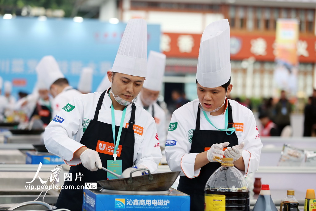11月1日,2025世界川菜烹饪技能大赛现场,参赛厨师正在烹饪特色菜。李华时摄(人民图片网)