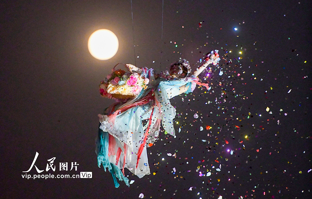 2025年11月5日,在河南省洛阳市洛邑古城景区,演员表演的“仙女散花”与“超级月亮”构成一幅美丽的画卷。张怡熙摄(人民图片网)
