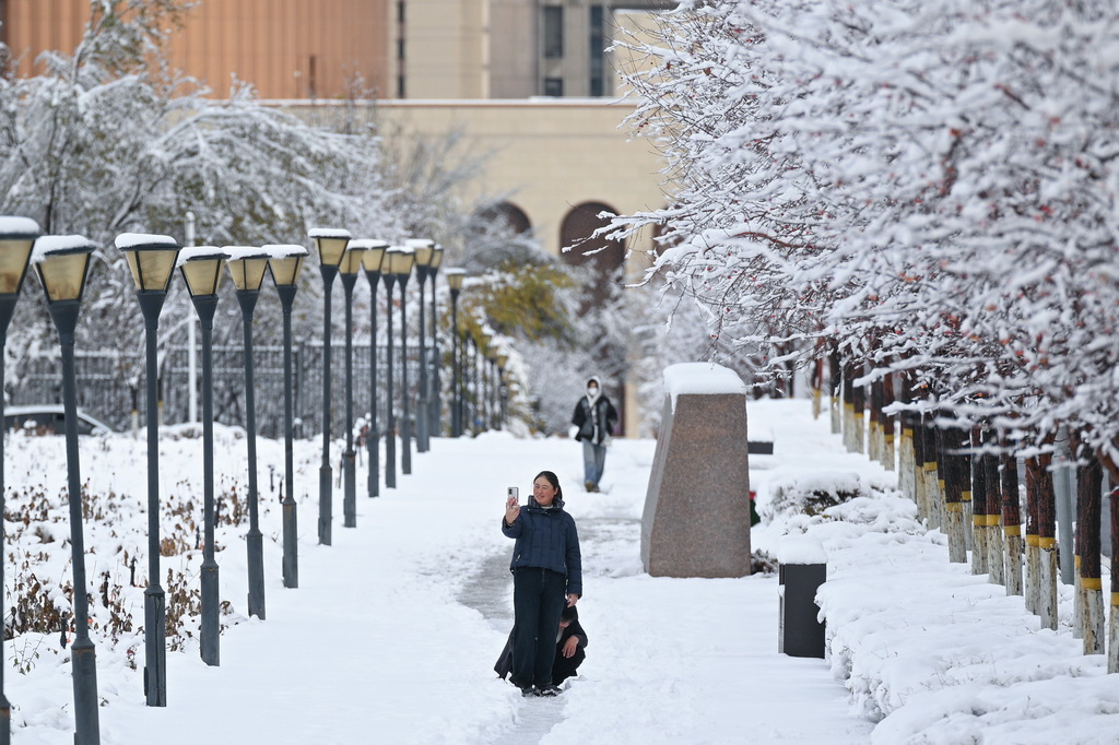 11月6日，人们在乌鲁木齐市水磨沟区拍摄雪后街景。新华社记者 辛悦卫 摄