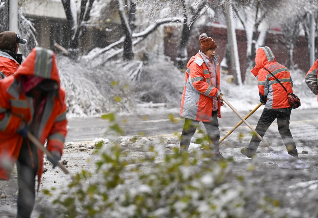 11月6日，在乌鲁木齐市红山路，环卫工人在清扫路面积雪。新华社记者 王菲 摄
