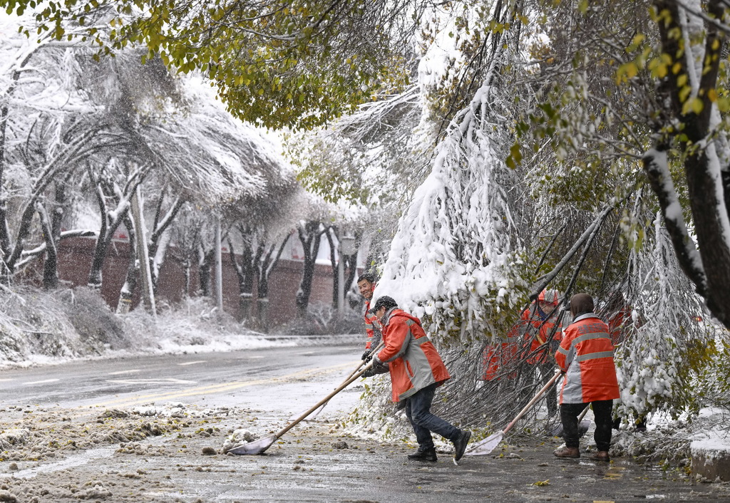11月6日，在乌鲁木齐市红山路，环卫工人在清扫路面积雪。新华社记者 王菲 摄