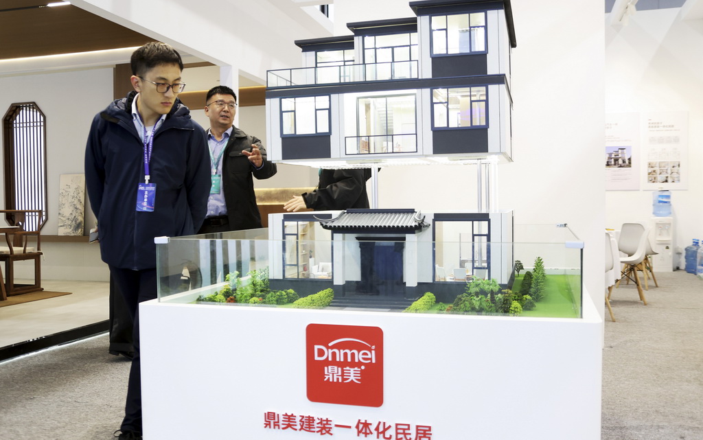 11月6日,参观者在住博会上观看展出的一体化民居模型。