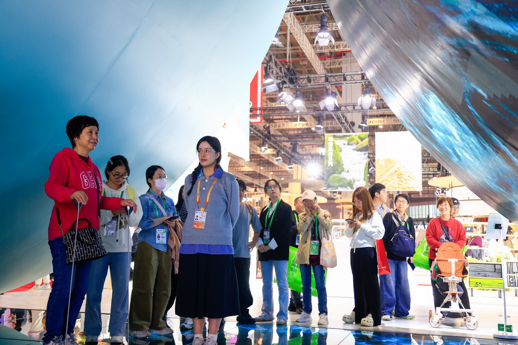 11月8日,在第八届进博会消费品展区,观众在一家精品买手品牌展台体验。新华社记者 刘佳琪 摄