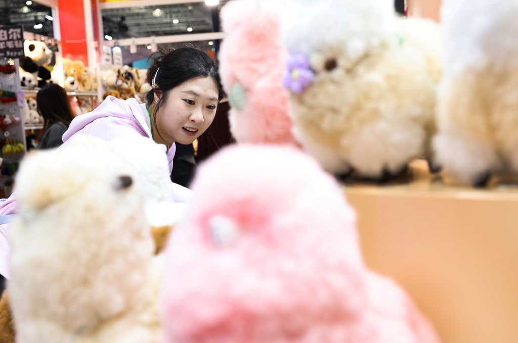 11月8日,在第八届进博会消费品展区,参观者在秘鲁温暖驼品牌的羊驼毛制品前驻足观看。新华社记者 方喆 摄