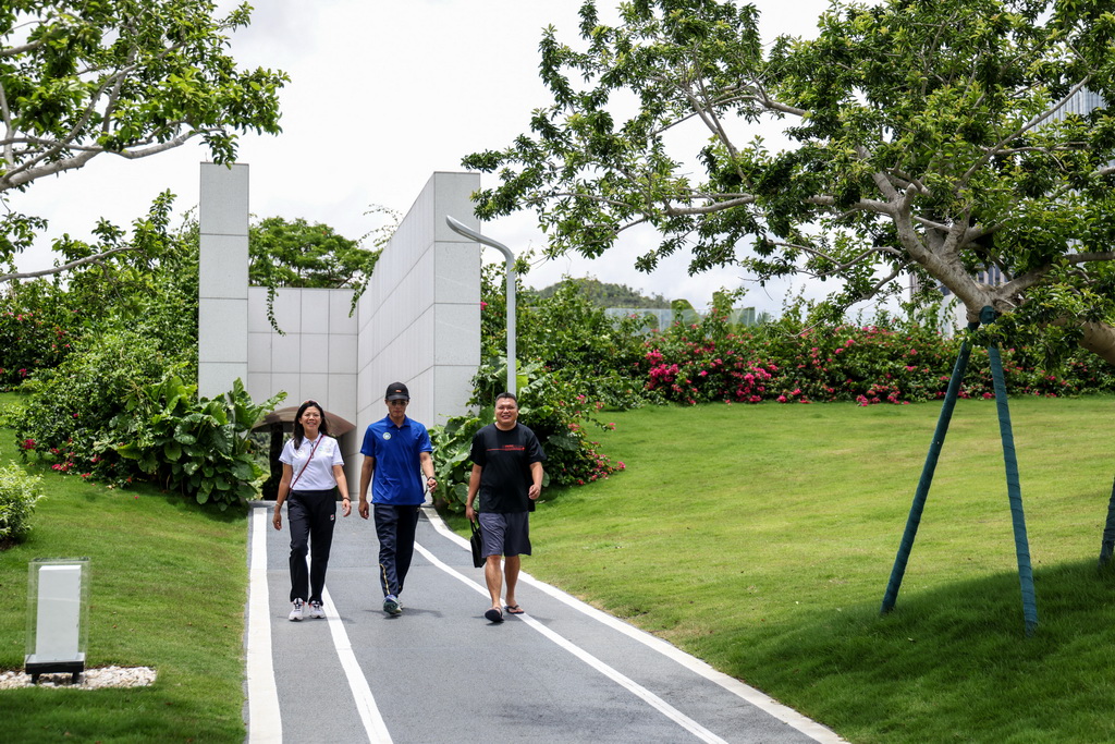 6月21日,天沐赛艇会的合伙人汤少文、朱铭琨和陈志鹏(由左至右)走在赛艇公园内。 新华社记者 毛思倩 摄