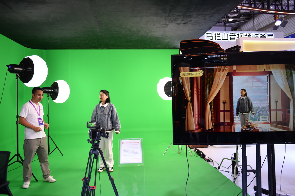 11月12日，观众在2025中国新媒体技术展上体验虚拟片场线下打卡系统。