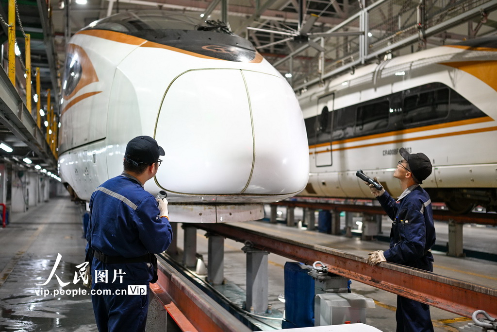 2025年11月15日凌晨，在南京动车段南京南动车运用所检修库，地勤机械师对车体外表进行检查。