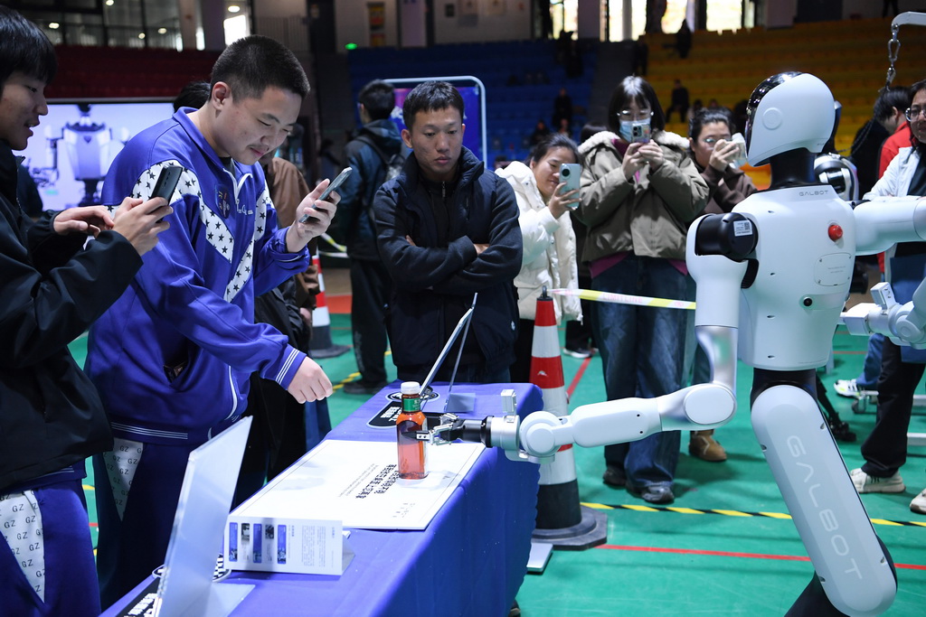 11月15日，在人形机器人演示现场，一款具身智能通用机器人为“消费者”拿取订购的商品。