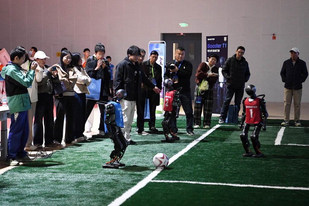 11月15日，人们在人形机器人演示现场观看一场机器人3对3足球赛。