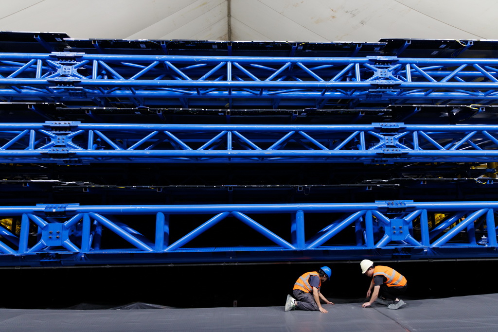 11月18日,工人在江门中微子实验大厅铺设地垫,其顶上三层是缪子探测装置。