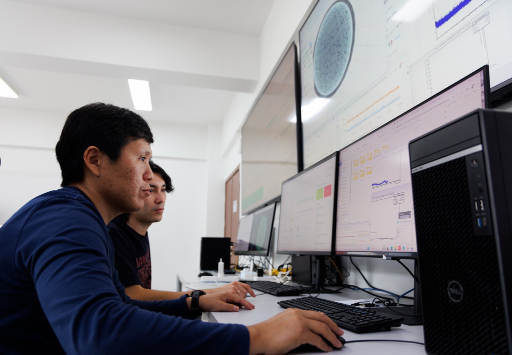 11月18日,科研人员在江门中微子实验运行控制室监测探测器运行情况。