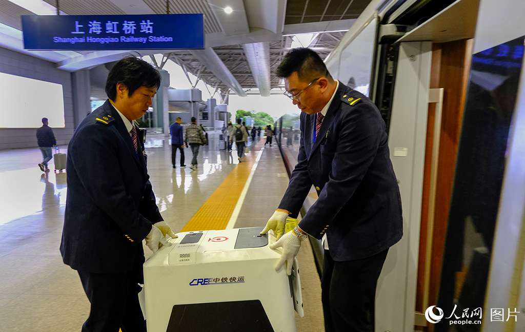 工作人员将宠物托运箱送至高铁车厢。