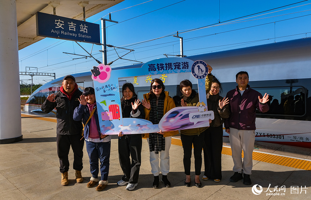 携宠游客在安吉站台上合影留念。