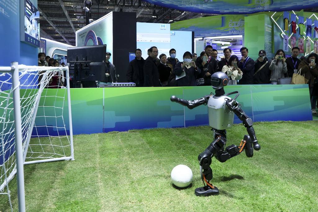 11月20日在江苏展区拍摄的机器人踢足球。
