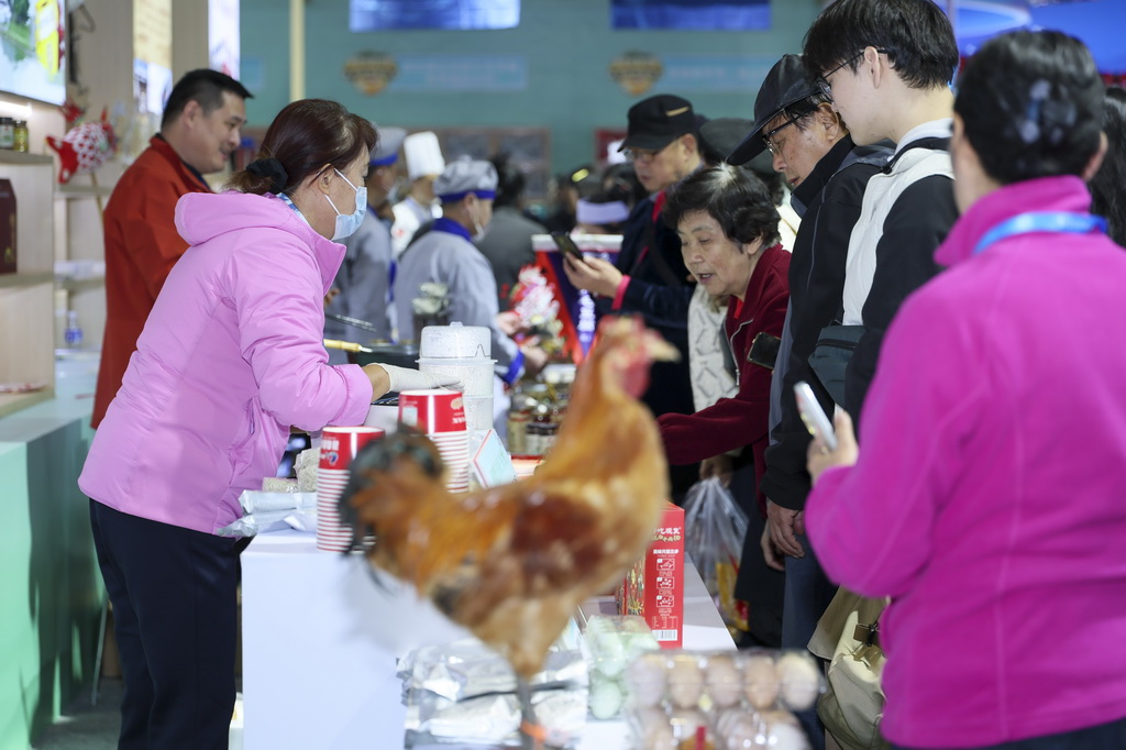 11月20日，观众在安徽展区体验美食。