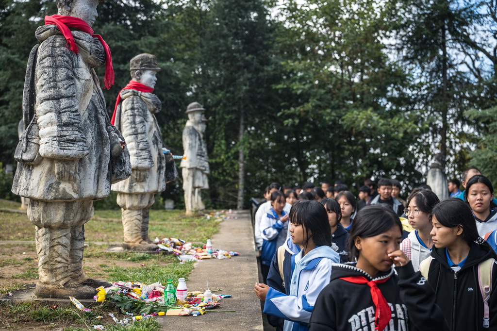 11月20日，芒宽民族中学学生在云南省保山市龙陵县松山战役旧址参观娃娃兵雕像。