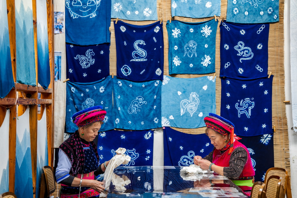 白族扎染技艺传承人段银妹（右）和手工艺人段利兰在周城村“璞真染坊”扎花（11月21日摄）。