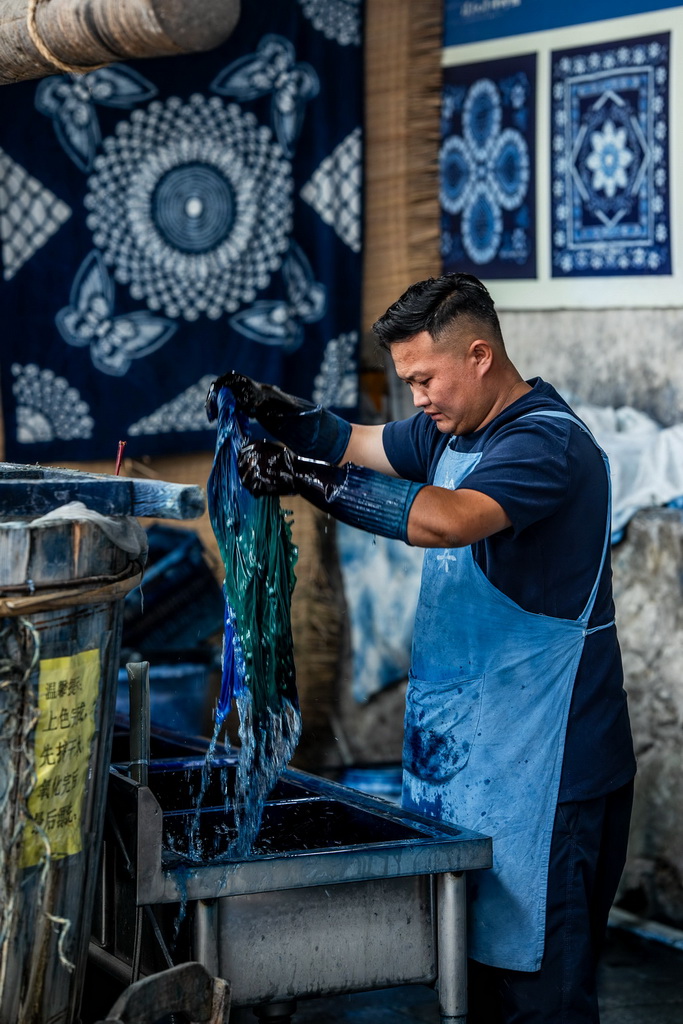 白族扎染技艺传承人段袁在周城村“璞真染坊”漂洗布料（11月21日摄）。