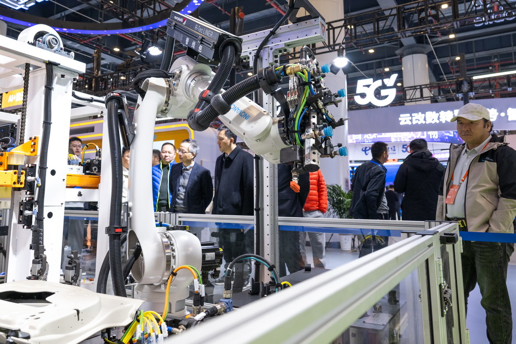 11月21日，参观者在2025中国5G+工业互联网大会展厅观看展出的一款柔性制造岛式工作站。该工作站能满足汽车制造领域的部件生产。新华社记者 肖艺九 摄