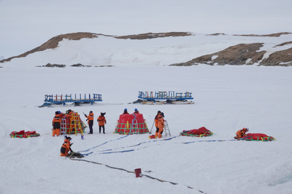 北京时间12月2日傍晚，工作人员在冰面上进行油囊加注作业。