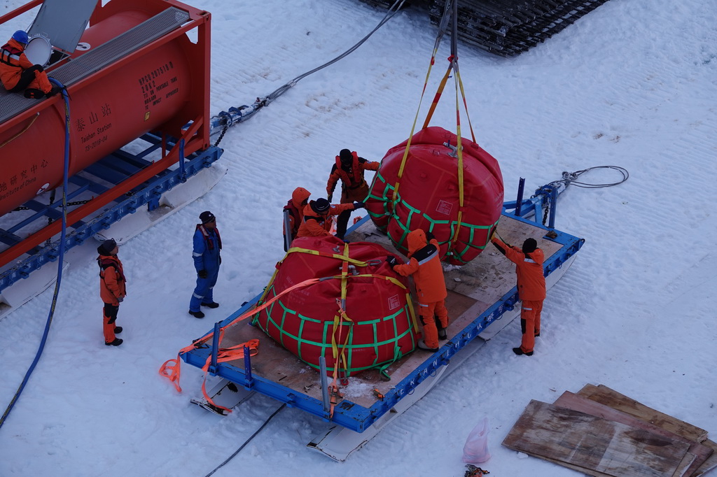 北京时间12月3日凌晨，工作人员在“雪龙2”号船侧冰面开展油囊装车作业。